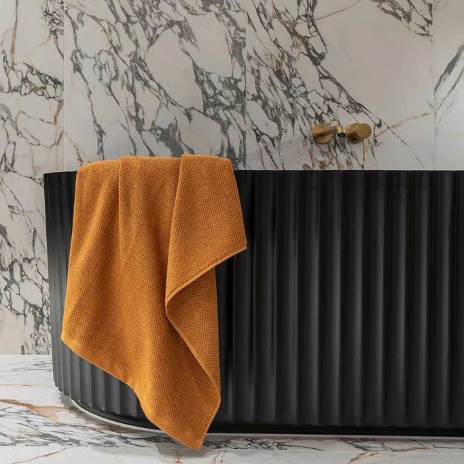 A matte black Agora Groove freestanding fluted bathtub in a modern bathroom.