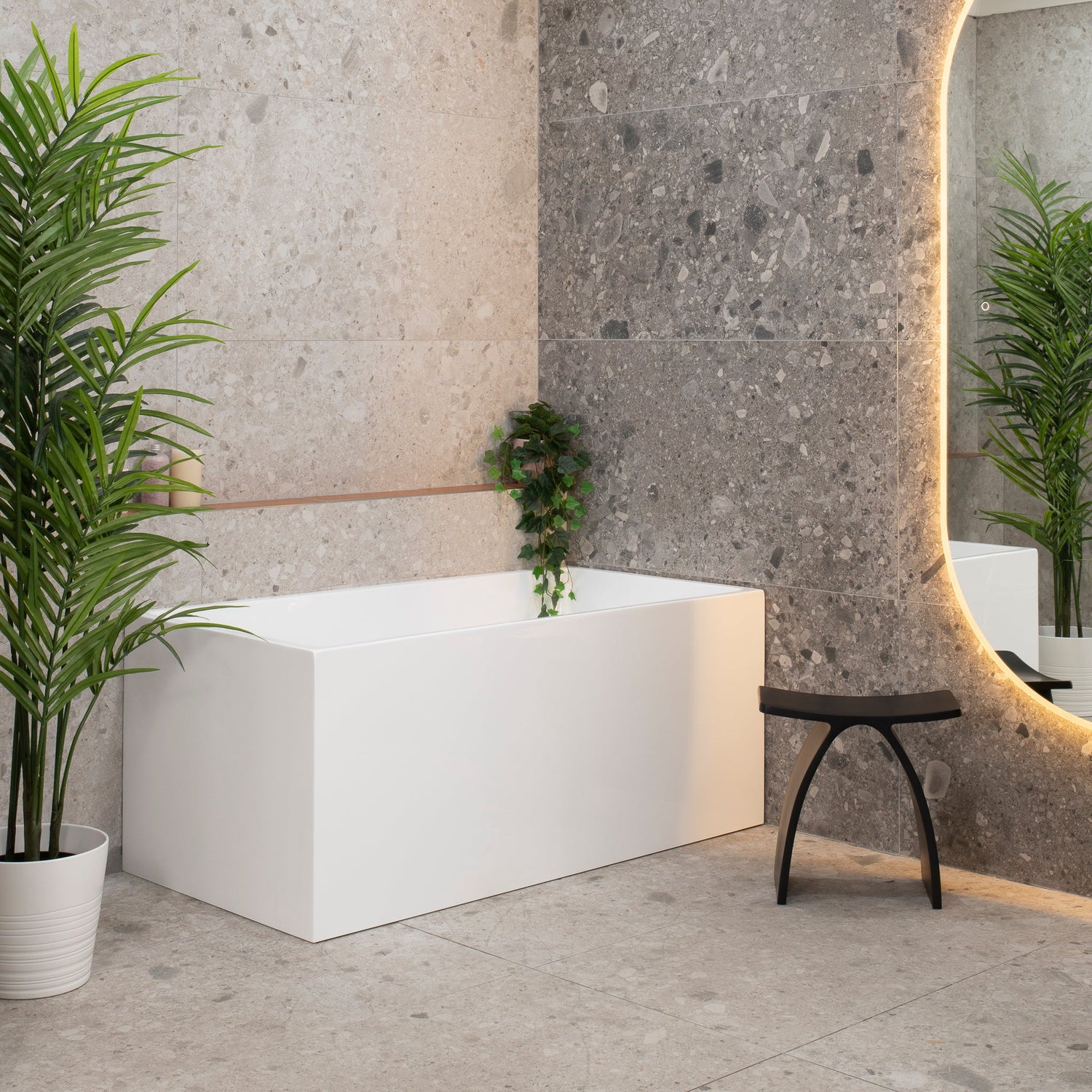 Cubix Square Multifit Freestanding Bath in matte white, set in a modern bathroom with stone walls and ambient lighting.